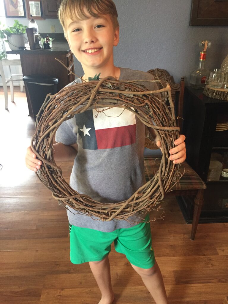 child holding a grapevine wreath