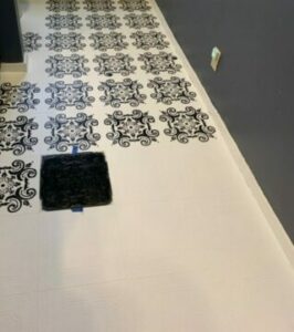 DIY Farmhouse flooring: progress, vinyl flooring painted white with black chalk paint stenciled folk art repeating pattern