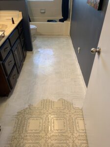 DIY farmhouse flooring: Ahhh, hideous vinyl flooring being painted over with a first layer of white primer.